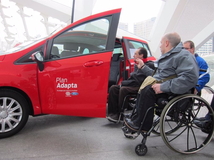 Personas discapacitadas observan un vehículo del Plan Adapta.