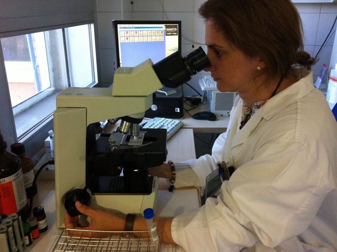 Investigadora con microscopio en laboratorio