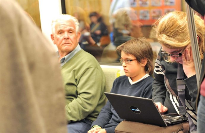 Mujer consultando un ordenador portátil en el metro