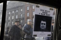 Ciudadanos ucranianos miran un cartel de Yanukovick