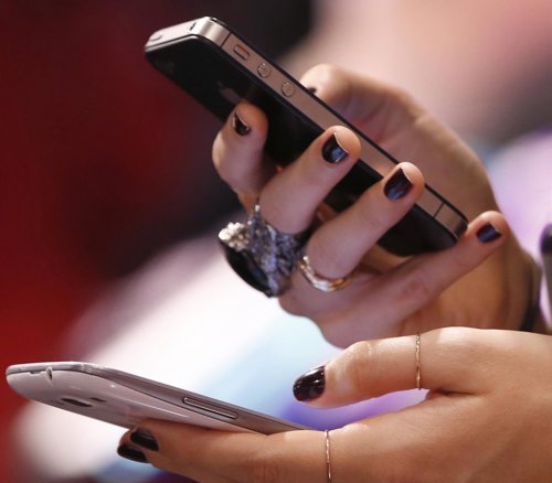 Una mujer usa un smartphone, Facebook