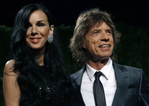 Designer L'Wren Scott and rock musician Mick Jagger pose as they arrive at the 2