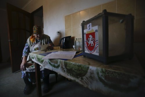 Mujer mira su voto durante el referéndum en Crimea