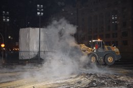 Una máquina retira ceniza tras la 'cremà' de la falla del Ayuntamiento