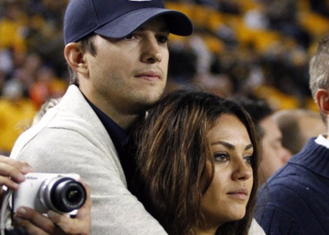 Ashton Kutcher and Mila Kunis look on from the s