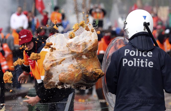 Manifestante tira basura a un antidisturbios en la Euromanifestación