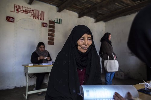 Una mujer afgana espera para recibir su tarjeta para votar
