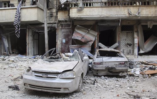 Coches destrozados en una calle de Alepo en el distrito de al-Sukari