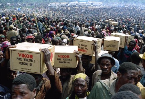 File photo of Rwandan refugees carrying food supplies away from a distribution p
