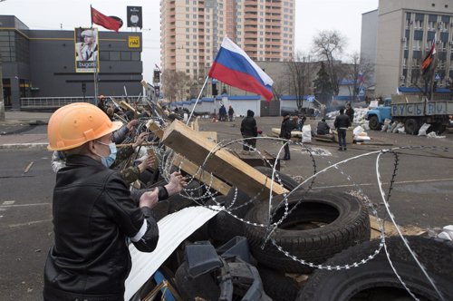 Pro-Russian protesters set a barbed wire on a barricade outside the SBU state se