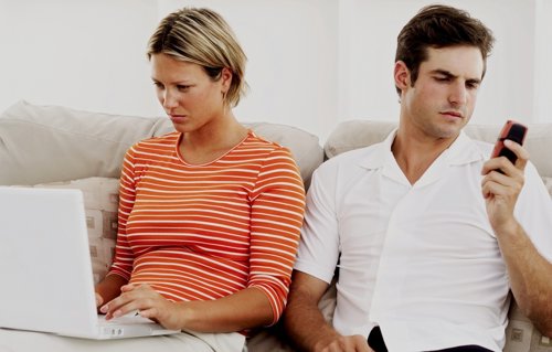 Pareja con movil y ordenador, internet, dependencia digital