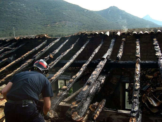 Un bombero observa el estado de las vigas del tejado.