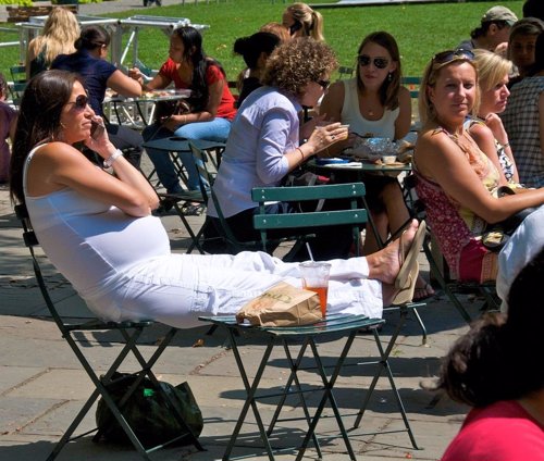 Embarazada comiendo en un parque