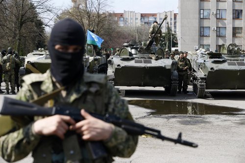 Armed men stand near armoured personnel carriers in Slaviansk