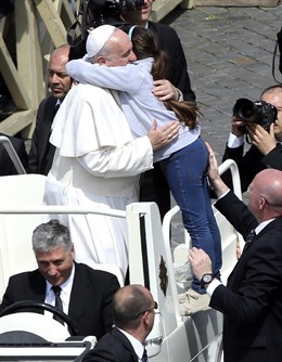 Pope Francis embraces a girl during the Palm Sunday mass at Saint Peter's Square