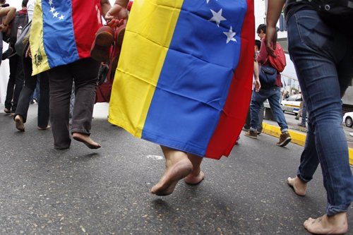 Anti-government protesters march barefooted during a protest in Caracas