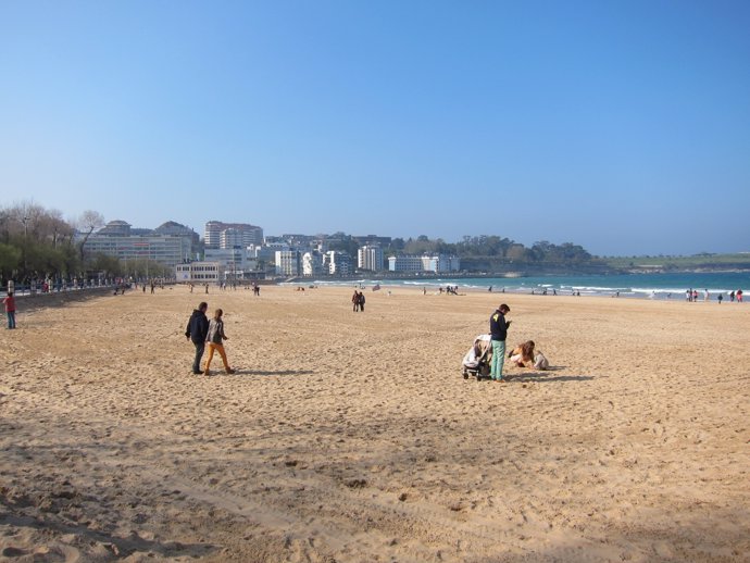 Gente pasenado por la playa en Santander 