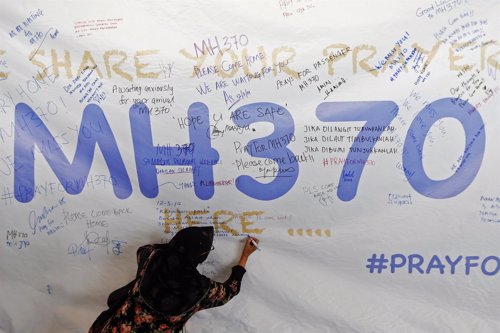 Una mujer escribe un mensaje de apoyo y esperanza por el vuelo MH370
