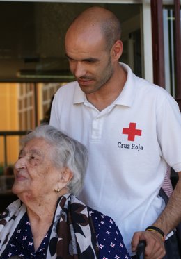 Voluntario De Cruz Roja Con Una Persona Mayor