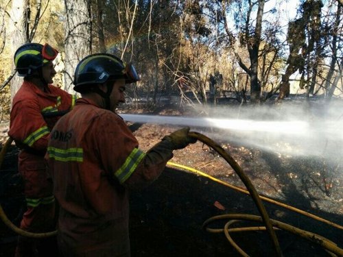 Bomberos refrescando la zona del incendio