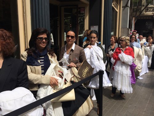 Asistentes al acto con sus vestidos y fotos para conseguir sus entradas