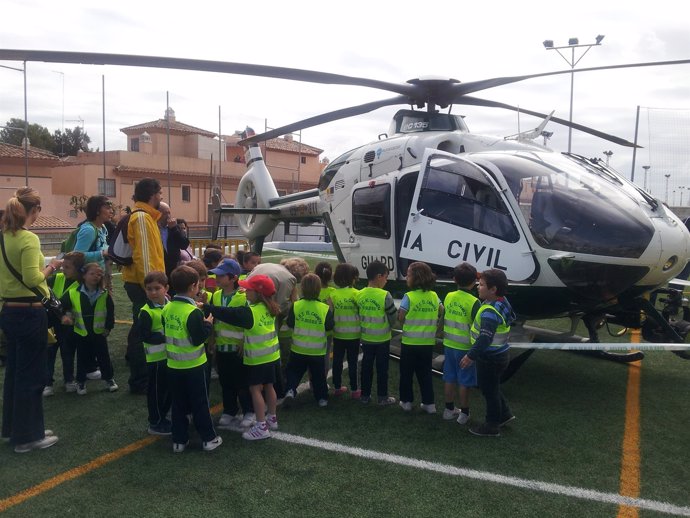 Niños junto a un helicóptero de la Guardia Civil