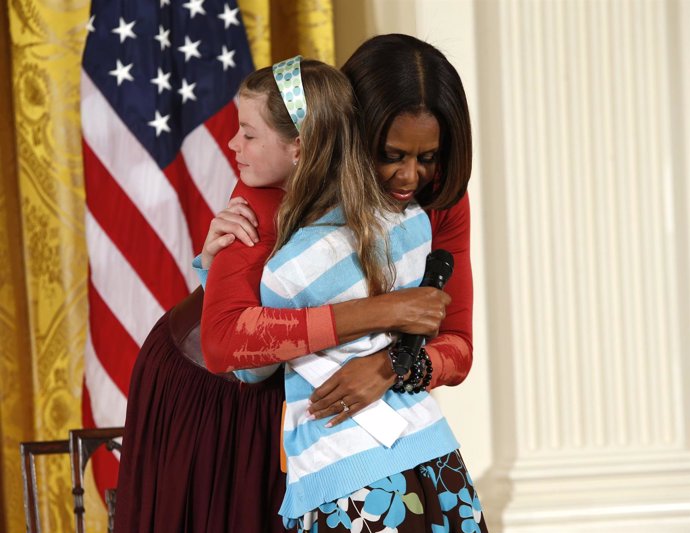 Michelle Obama abrazando a una niña
