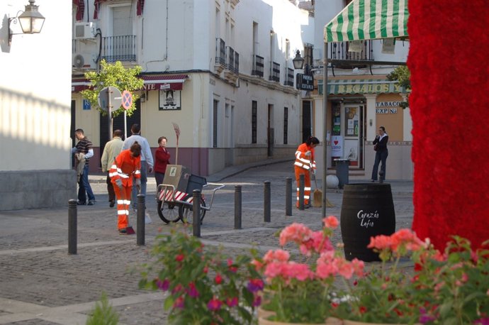 Operarios de Sadeco limpian junto a una cruz de mayo