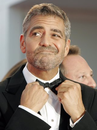 U.S actor George Clooney adjusts his bow tie 