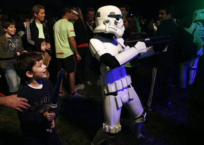 A boy looks at a man dressed as a stormtrooper from the Star Wars movies before 