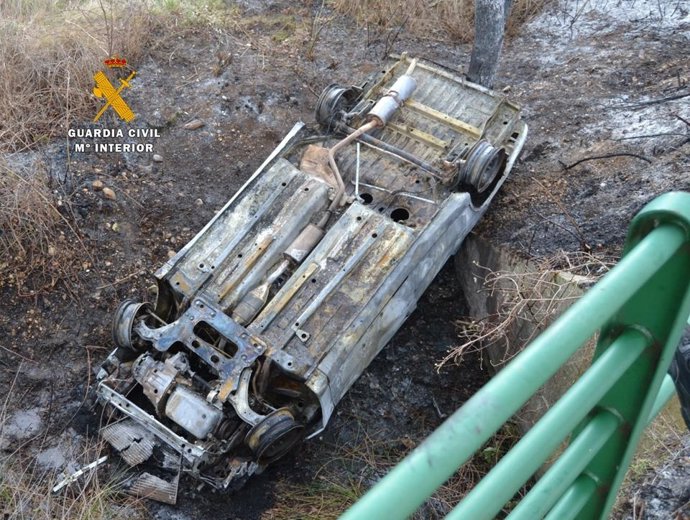 Coche calcinado localizado en un talud. 
