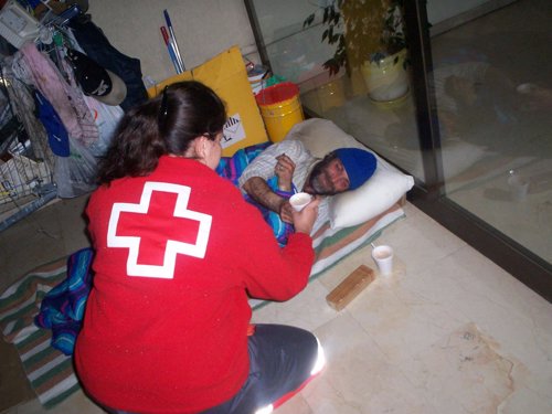 Un voluntario de Cruz Roja atiende a un hombre. 
