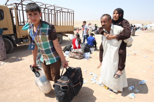 Familia siria cruza la frontera hacia un campo de refugiados