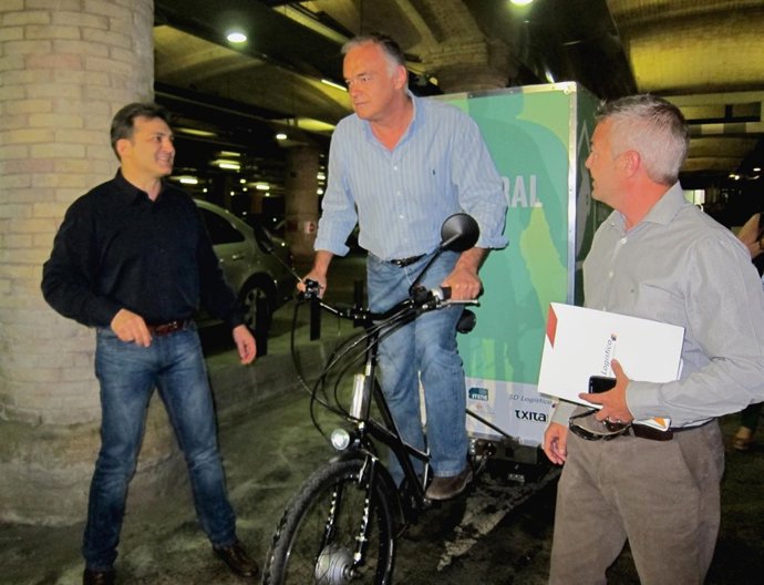 González Pons sobre una bicicleta de reparto en el Mercado Central