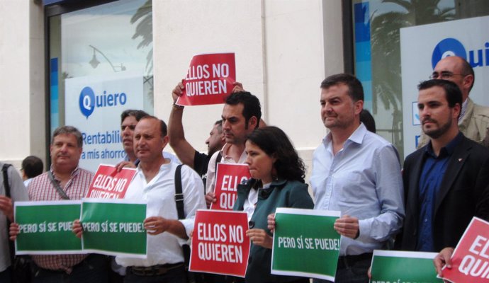 Responsables y militantes de IU frente a una sucursal bancaria