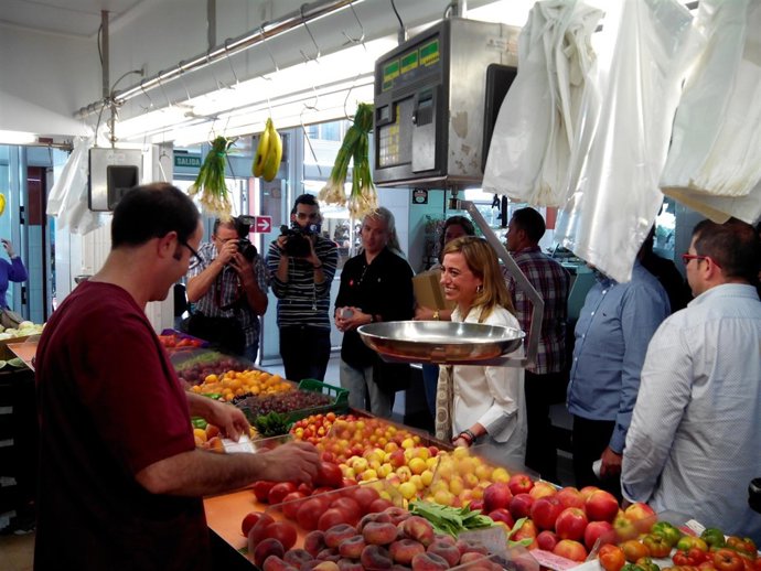 Carme Chacón habla con un comerciante en el Mercado de Carolinas