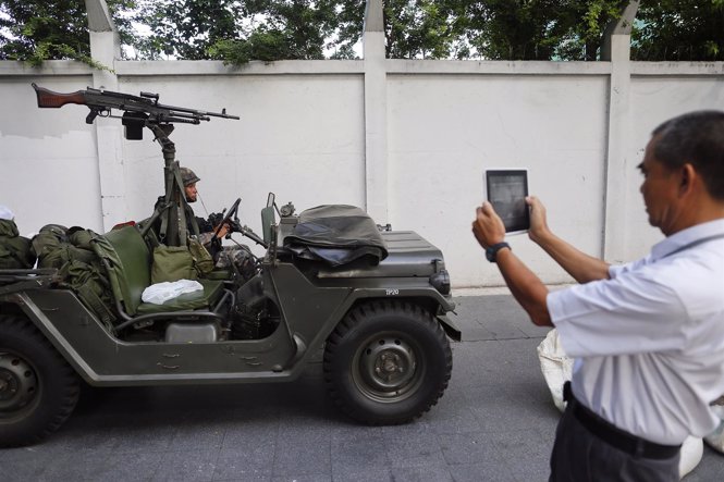 Un civil toma una fotografía de un militar en Bangkok