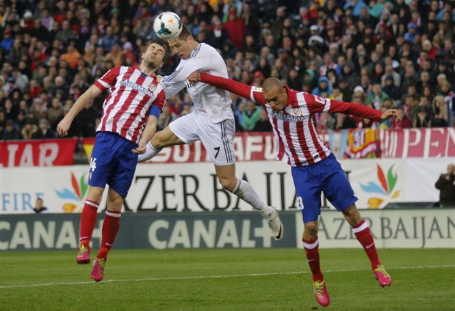 Cristiano Ronaldo (Real Madrid) cabecea la pelota entre Gabi y Miranda (Atleti)
