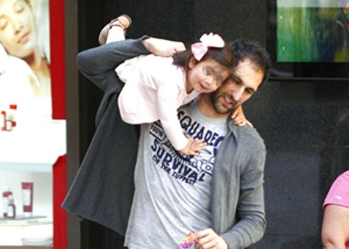 Diego López como un niño con su hija Zoe en el carrusel