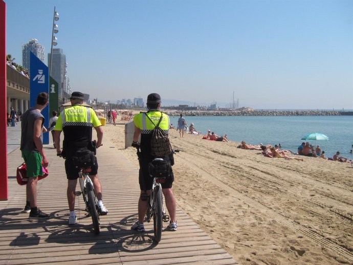 Dos agentes de la Guardia Urbana en la playa del Somorrostro de Barcelona