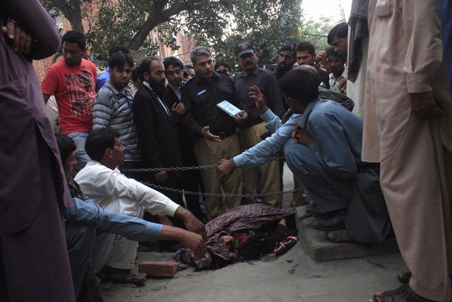 Policí al lado del cuerpo de Farzana Iqbal, asesinada por familiares