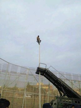 Inmigrante subido a una farola en la valla de Melilla