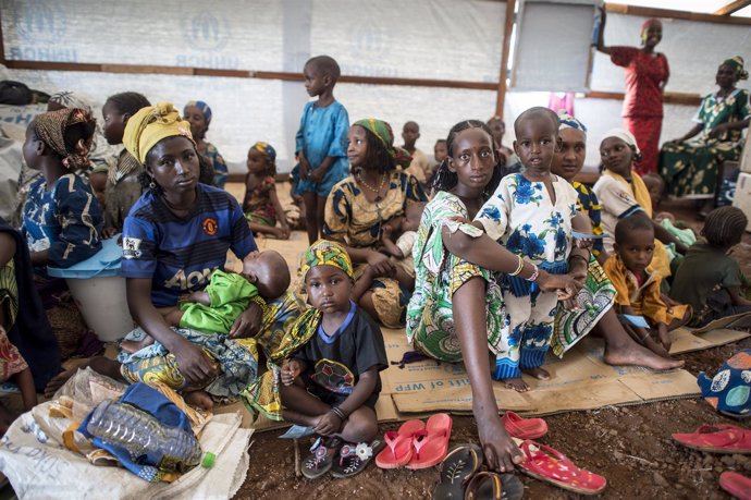 Mujeres y niños esperando a la entrega de alimentos en un campo de refugiados