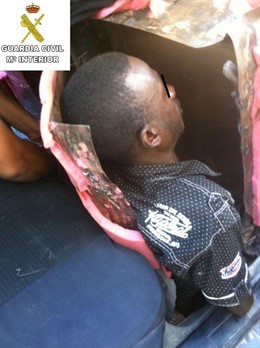 Un inmigrante oculto en el asiento delantero de un coche
