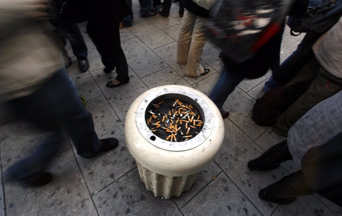 Fumadores frente a un cenicero en la calle