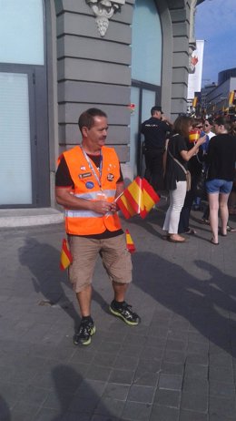 Un voluntario con los banderines para la proclamación de Felipe VI