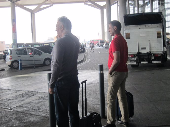 Dos turistas aeropuerto de Málaga viajeros maletas turismo coches
