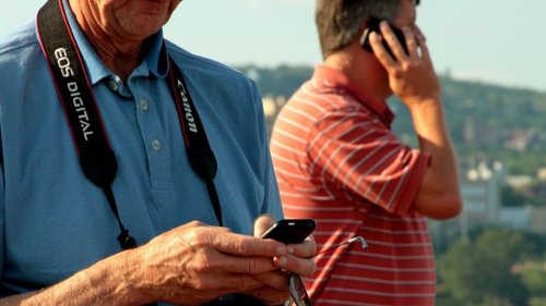 Turista en la playa con cámara y teléfono móvil smartphone verano vacaciones