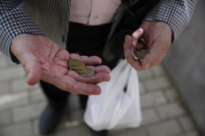 Español cuenta sus monedas para hacer la compra