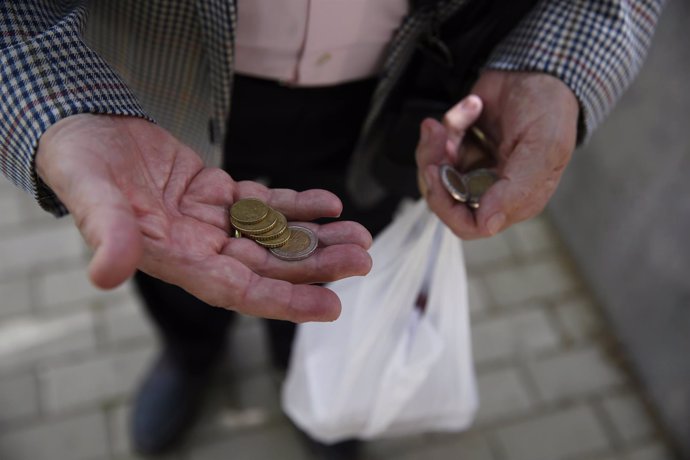 Español cuenta sus monedas para hacer la compra